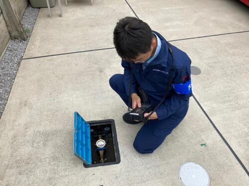 写真：メーターボックスを開けて検針する様子