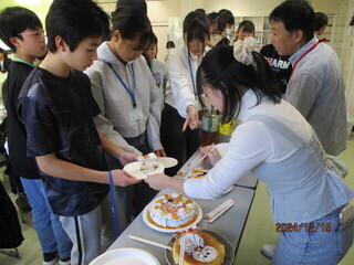 写真：ケーキを配っている様子