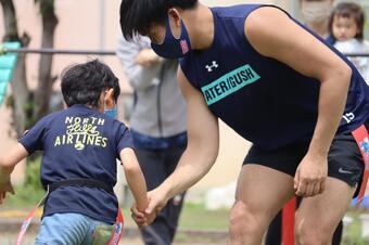 写真：子供がタグを取られないように選手から逃げている様子