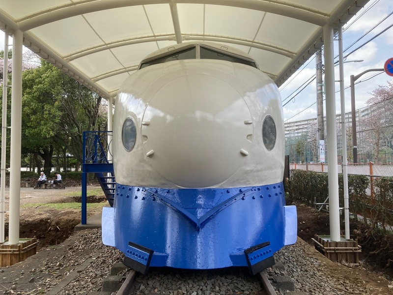 屋根の下にある正面からみた新幹線の写真