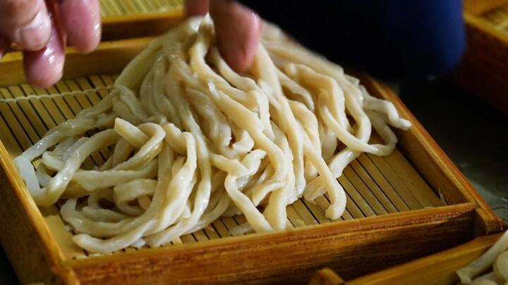 写真：うどんの盛り付けをする様子