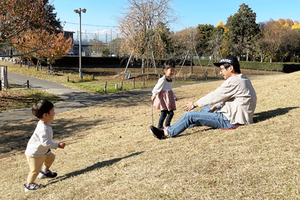 写真：エコパークで丘滑りをしているお父さんと子ども
