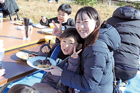 つきたてのおもちをほおばる親子の写真