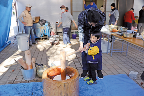 もちつきをする親子の写真
