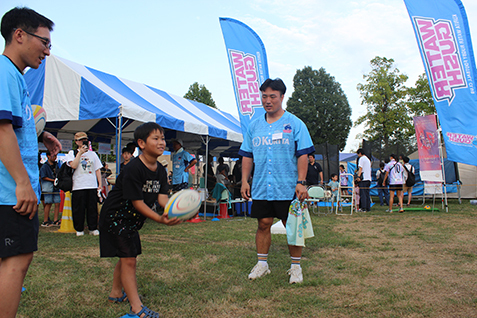 選手とラグビー体験をする子どもの写真