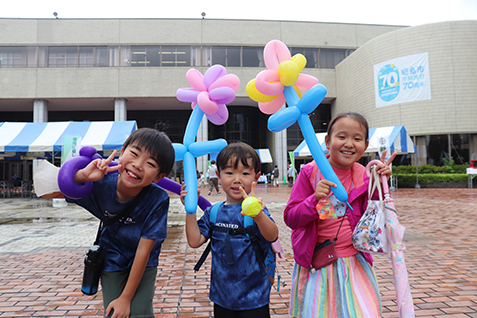 バルーンアートを手に喜ぶ子どもたちの写真