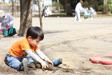 砂場で泥団子を作る子どもの写真