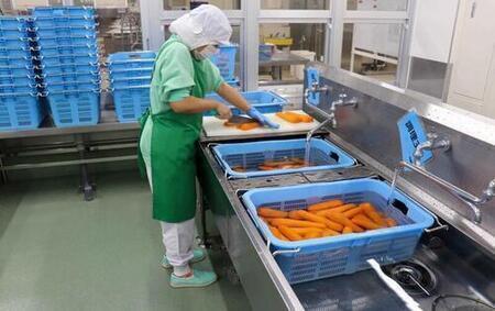 調理場でニンジンを洗ってるようす