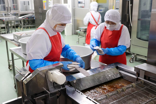 魚をフライヤーに入れる写真