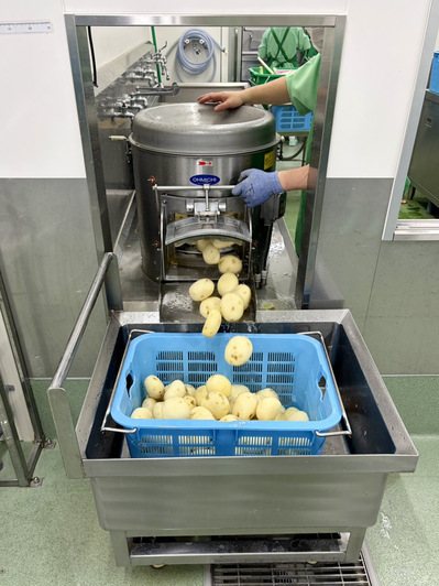 皮むき器から皮が剥けたジャガイモが出てくる写真