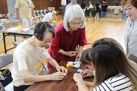 折り紙を折る高齢者と親子