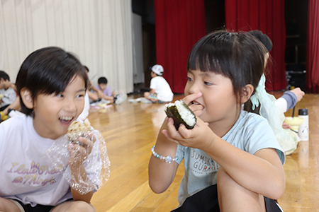 おにぎりを食べる子どもたちの写真