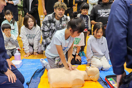 自治会防災運動会で、心臓マッサージを体験している写真