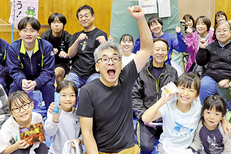 自治会長の周りに自治会に参加している人たちが集まっている写真