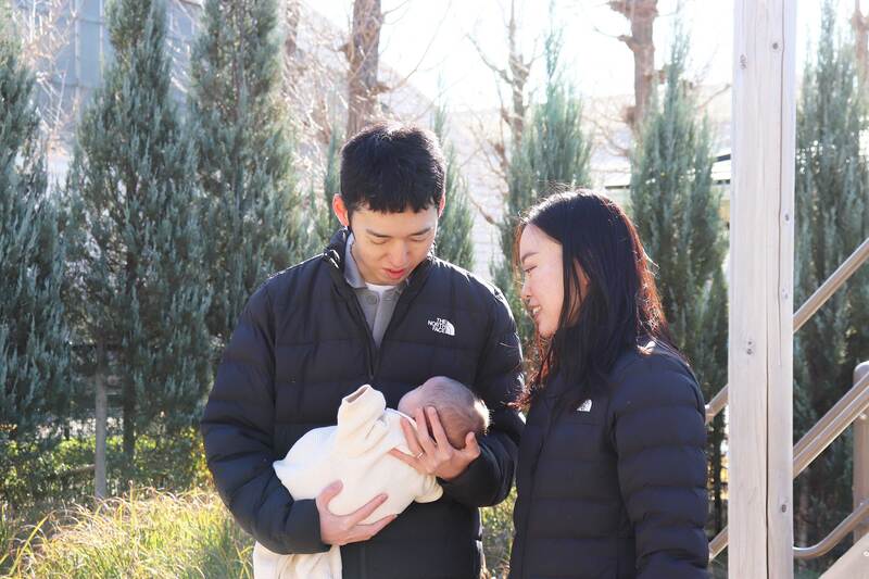 画像：赤ちゃんを抱く夫婦