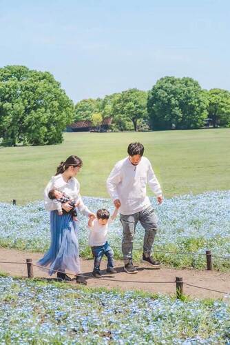 画像：昭和記念公園のみんなの原っぱで家族で歩いている写真