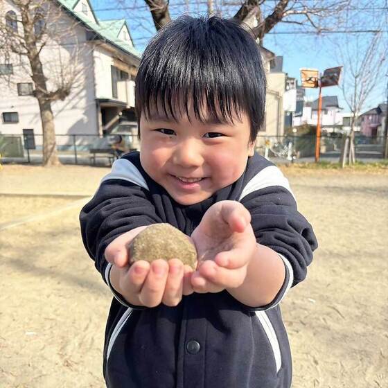 画像：公園で作ったきれいな泥団子を持っている男の子