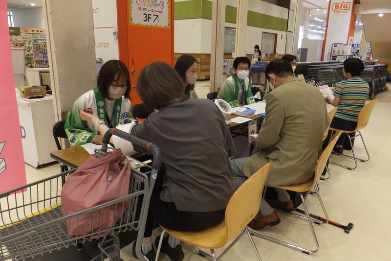 スーパーで血圧測定を受ける人