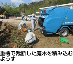 重機で裁断した庭木を積み込むようす